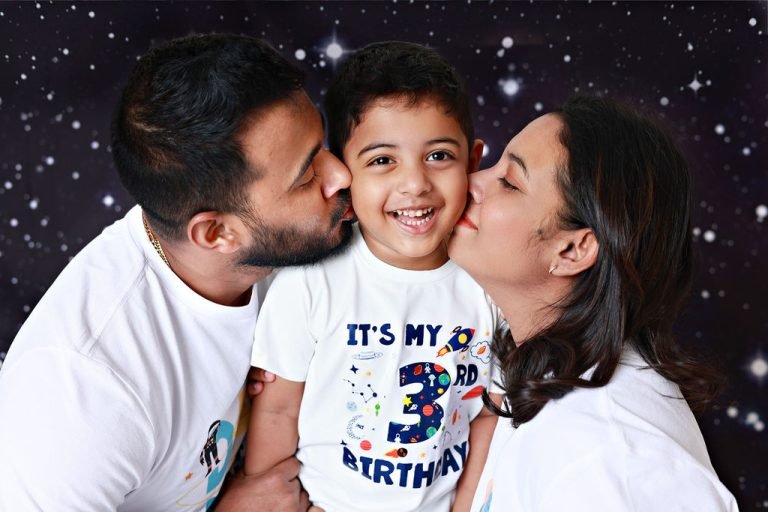 Parents kissing their son's cheeks at his third birthday photoshoot